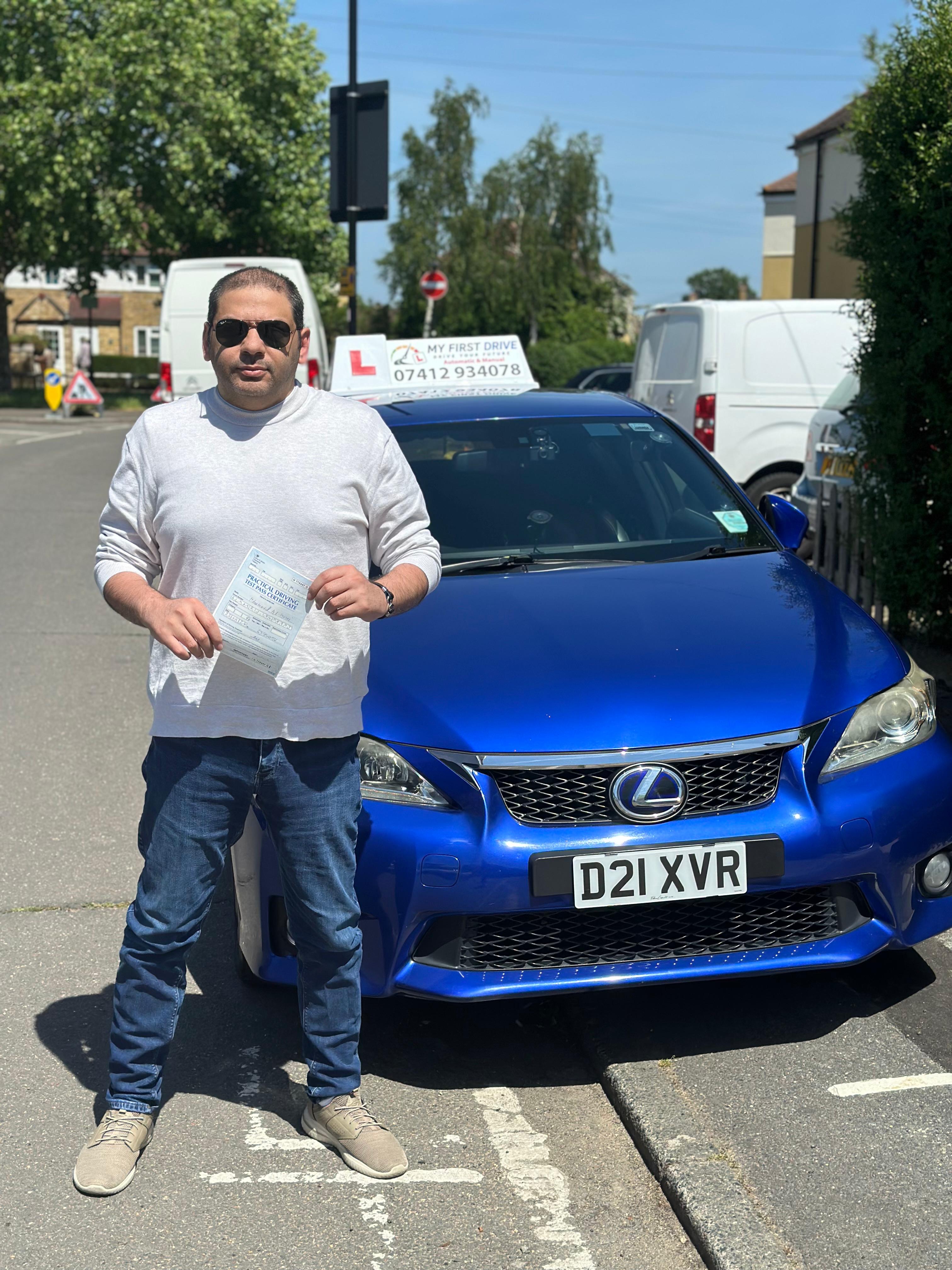 A happy learner holding their driving test pass certificate by the My First Drive car